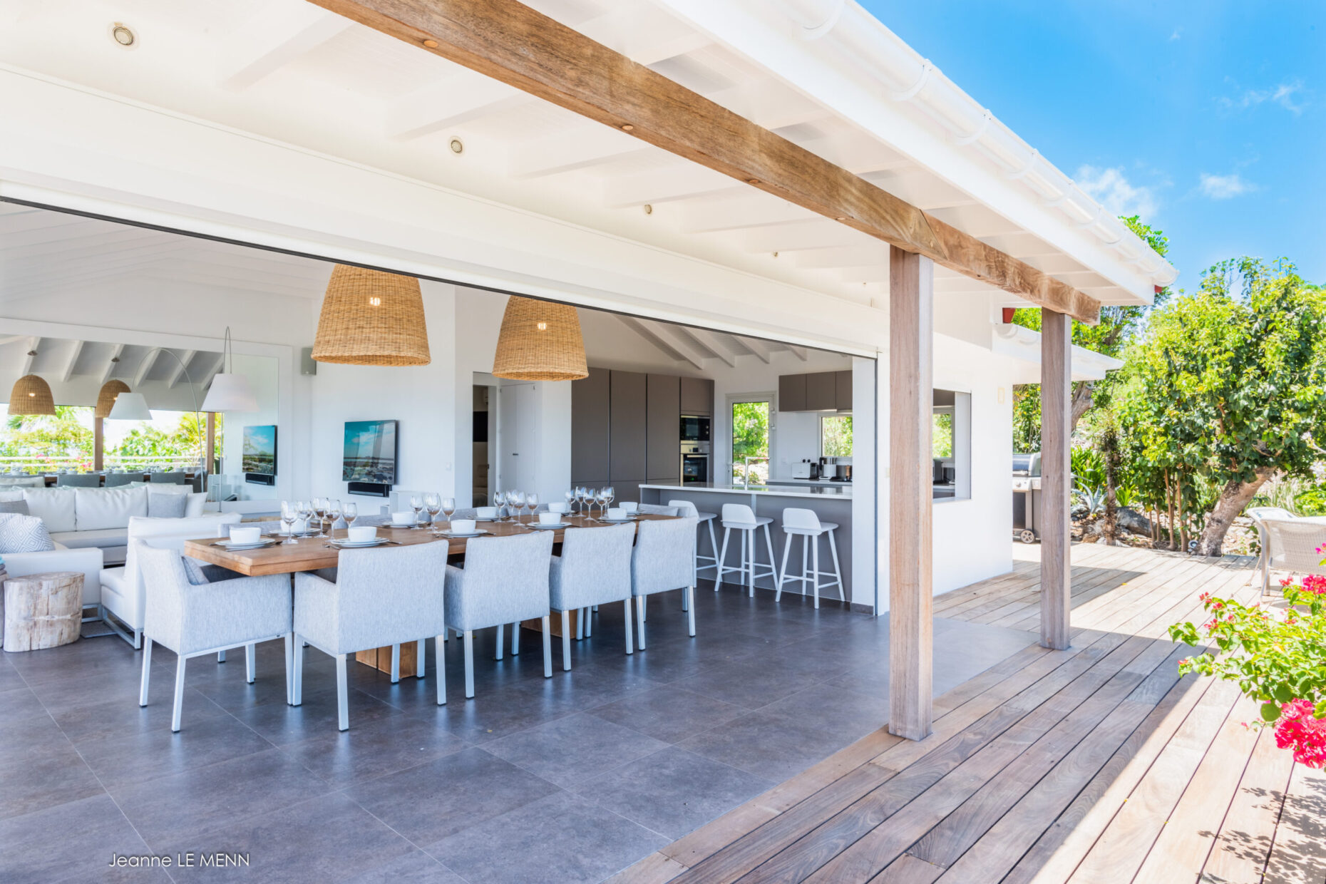 Woven armchairs on a wooden deck with ocean views at Villa Avalon