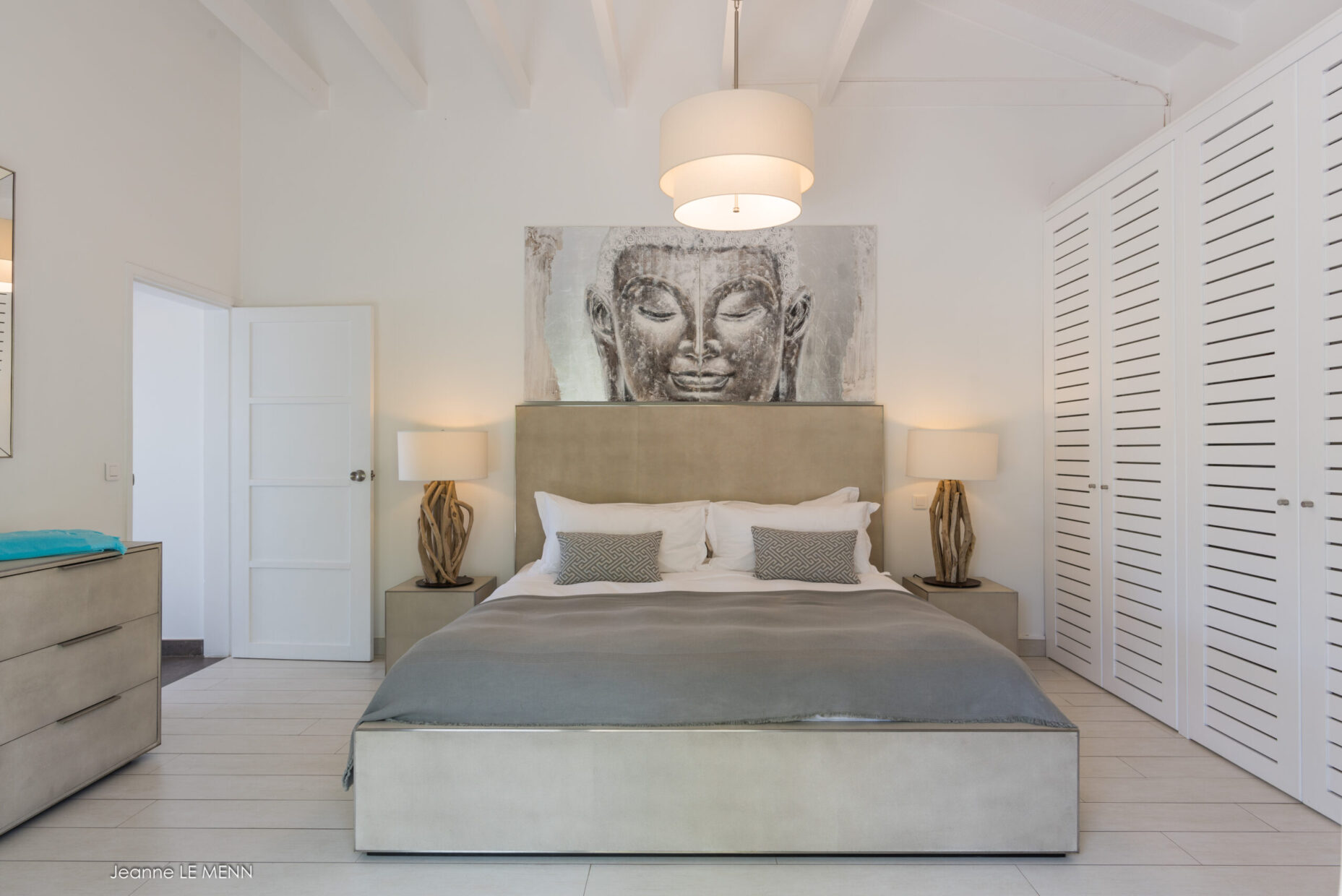 Modern bedroom at Villa Avalon with Buddha artwork and minimalist white decor.