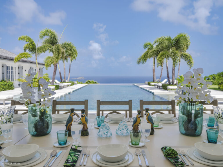 Outdoor dining table overlooking the infinity pool and ocean at Villa Antares, St. Barts.