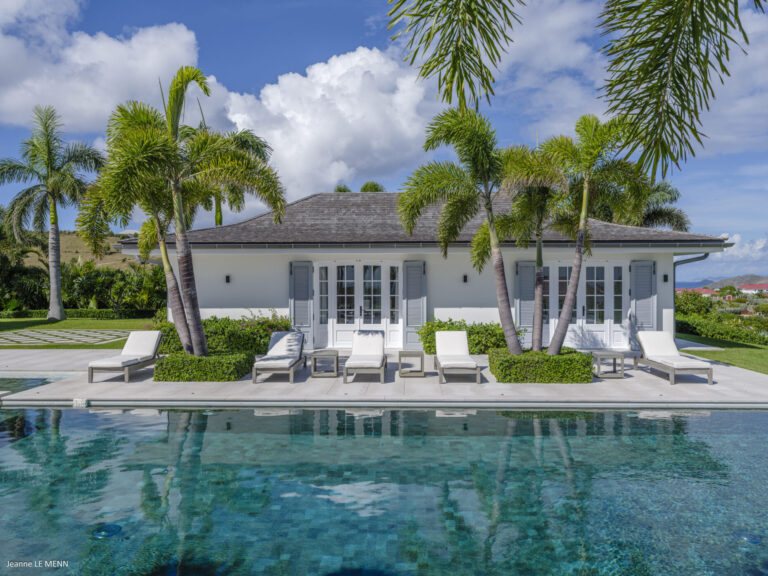 Palm-lined pool terrace in front of the villa at Villa Antares, St. Barts.