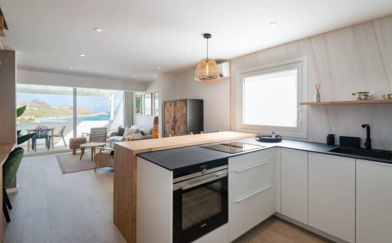 Modern kitchen opening to lounge and sea-view terrace at Villa Aqua, St. Barts.
