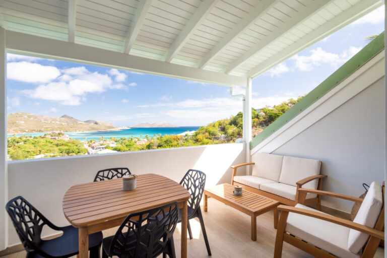 Covered terrace with dining table and panoramic sea view at Villa Aqua, St. Barts.