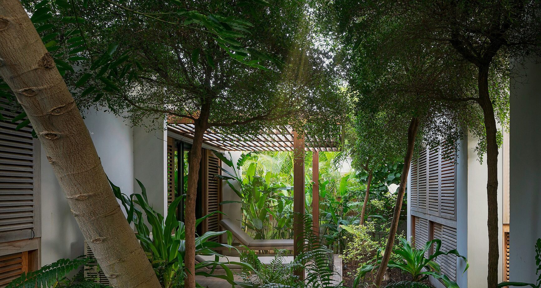 Lush tropical courtyard with shaded lounge area at Villa Caro, St. Barts.