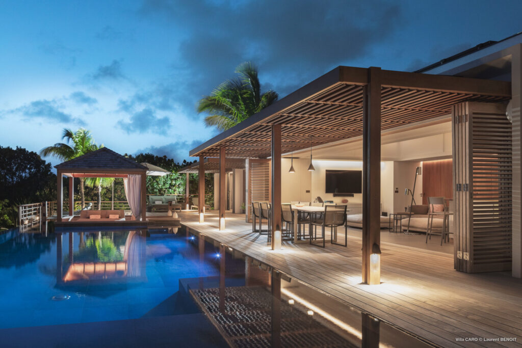 Evening view of poolside terrace and open-air lounge at Villa Caro, St. Barts.