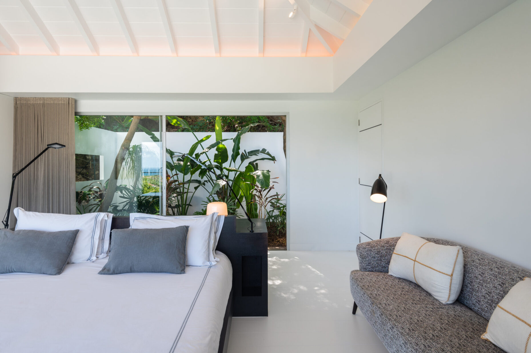 Serene bedroom suite at Villa Wings St. Barts with tropical garden view.